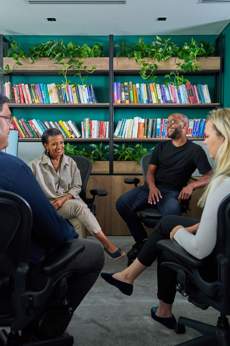 Staff members meeting in the library.