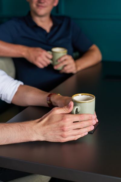 A staff member holding a cup of tea.