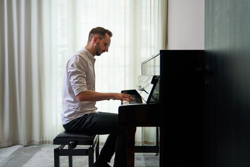 A staff member playing the piano in the music room.